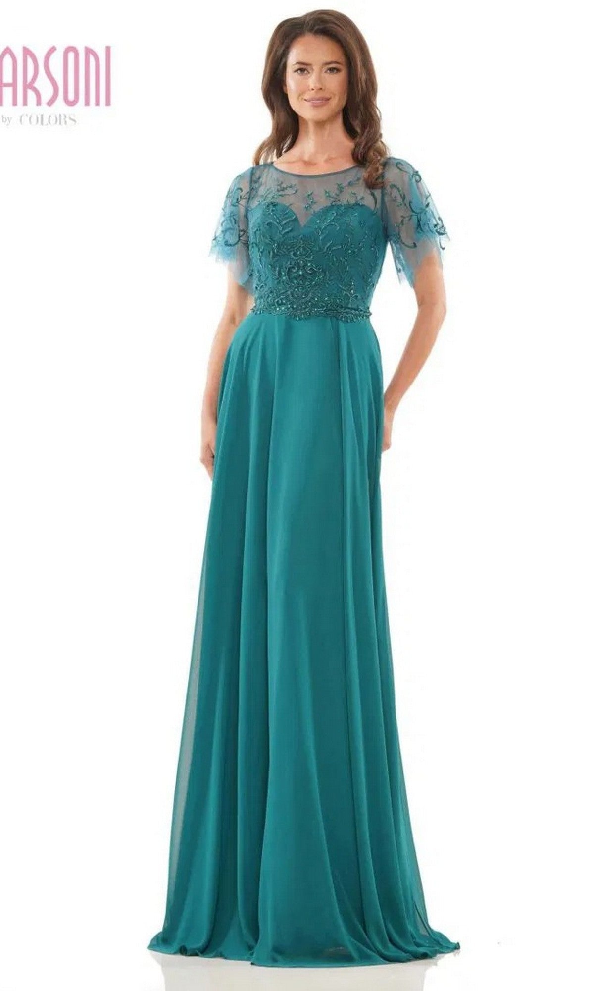 A woman wears the Marsoni M323 long formal dress in deep green, featuring chiffon fabric, an A-line skirt, sheer short sleeves, and a floral beaded bodice, posed against a plain white background.